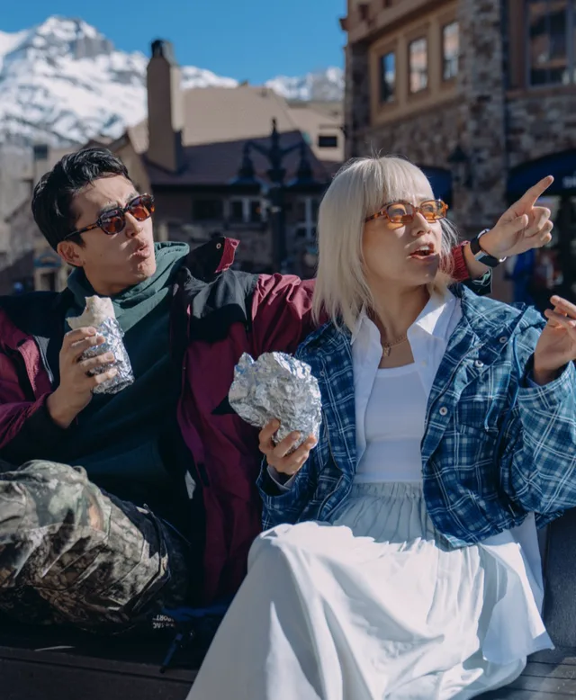 Two members eating outside in a mountain town